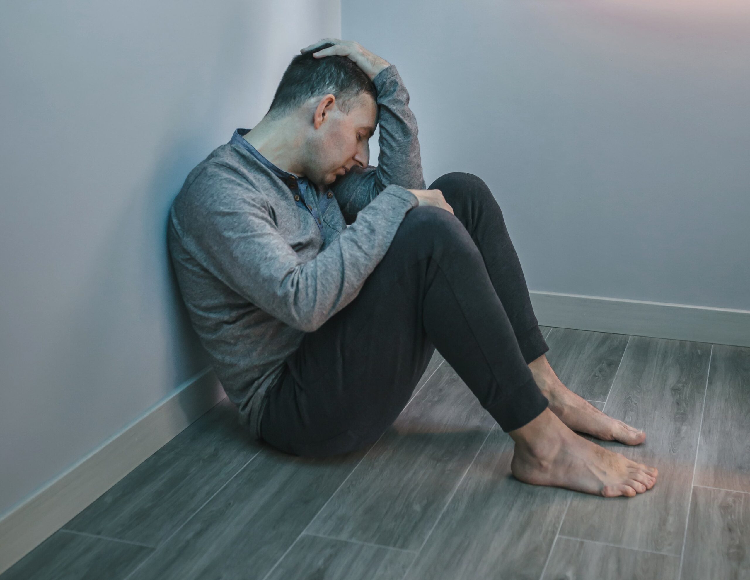 Stressed and tired man with problems resting sitting on the floor